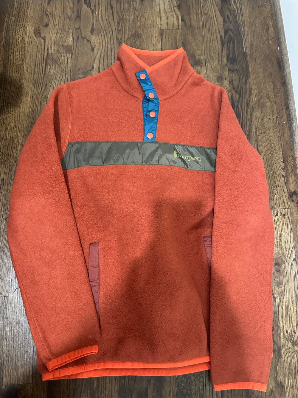 cotopaxi Orange Fleece Turtleneck with Blue Snap Placket and Olive Chest Stripe